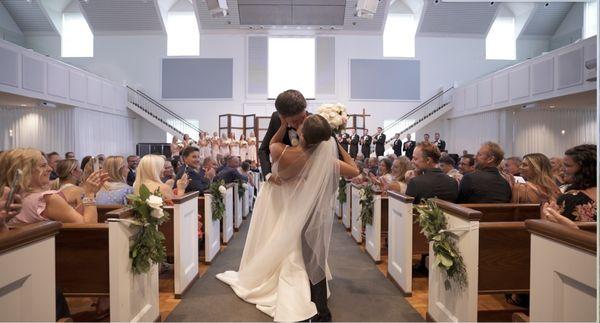 Husband and wife dip and kiss after their ceremony