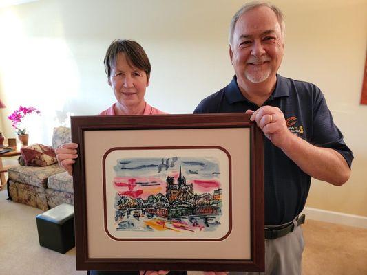 Happy customers after purchasing an embroidery showing the Notre Dame Cathedral in Paris, France
