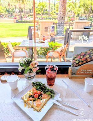 salmon crepe and mixed berry soda with view of outdoor seating