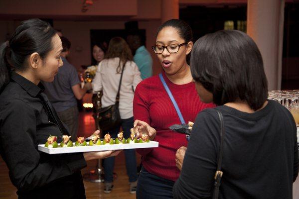 NYC event guest choosing passed hors d'oeuvre from a Tapuz Server