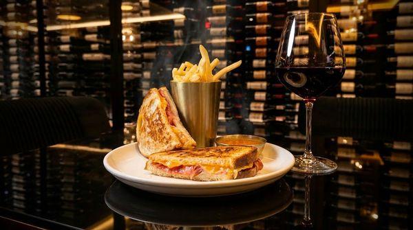 The Elevated Melt- Toasted sourdough bread, cheddar, swiss, gruyère and parmesan, sliced speck, tomato soup accompaniment, served with fries