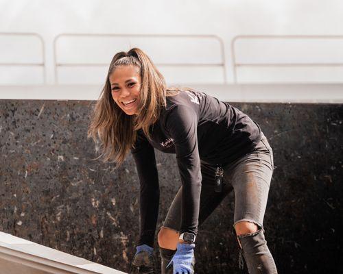 Our co-founder Brooks smiling with a black shirt and pants on about to pick up old materials.