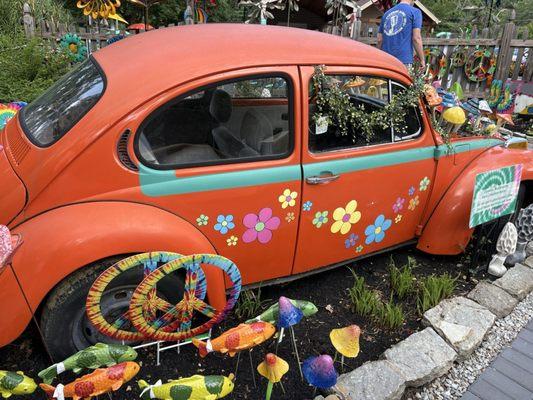 An old VW bug with yard Art