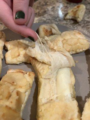 Raw dough. The cheese is clearly still in stick form, not melted.
