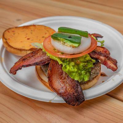 Our Chris Cross Burger. Bison with smoked peppered bacon on a toasted Brioche Buns with lettuce, tomato, and onion. Topped with Jalapeno.