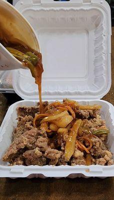 DIY pour of the sweet and sour sauce on the crispy beef.