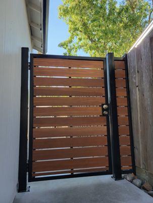 Modern side gate with black metal frame and horizontal wood slats - clean, stylish, and functional design for side entrances.