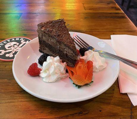 Triple Chocolate Cake garnished with fruit and whipped cream!