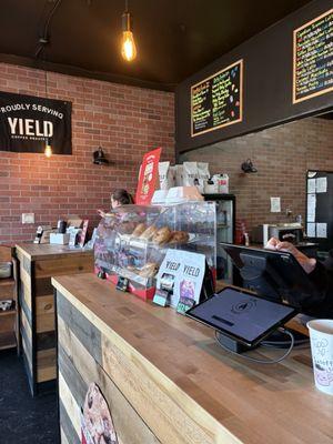 Counter with small assortment of muffins, etc. with partial view of menu