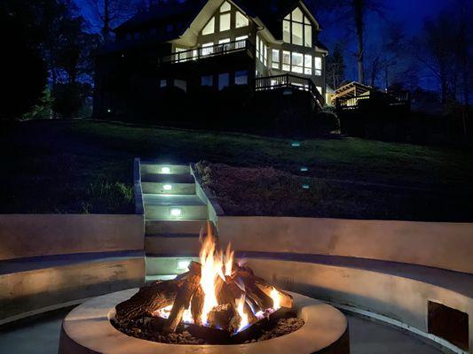 Concrete fire pit seating area with steps, integrated lighting and USB ports