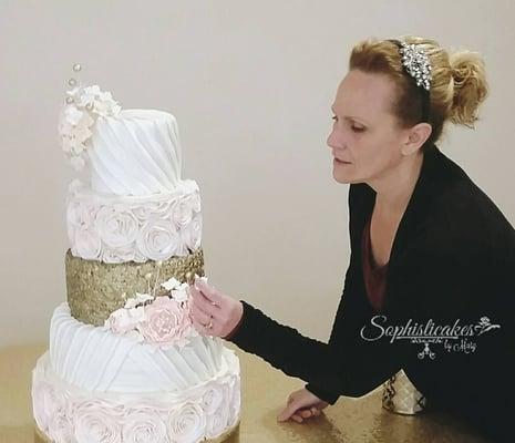 Mary, owner and operator of Sophisticakes By Mary, putting the finishing touches on a wedding cake.