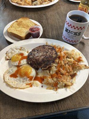 Simple breakfast with sausage patty , eggs hashbrowns and sourdough
