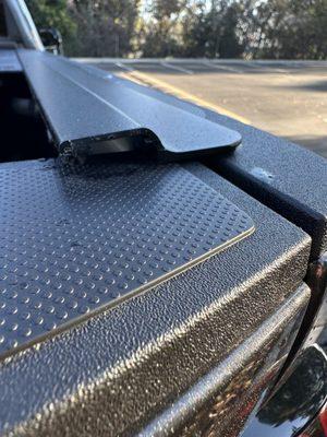 Cover that goes on the end is missing. Tailgate trim is scratched so badly. It's going inwards more when it should sit flat and straight