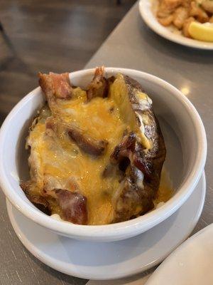 Baked potato slathered with cheese and strips of bacon