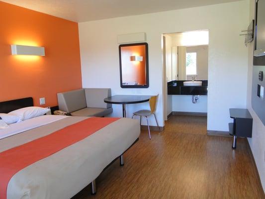 King Room features a platform bed, bamboo flooring, sleek furnishings, flat screen TV, granite vanity with vessel sink & other funky touches