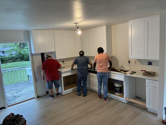 3 workers installing granite