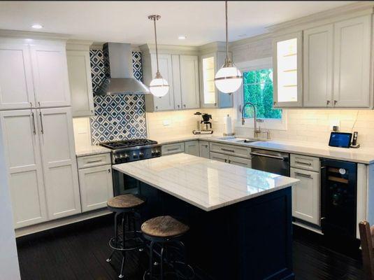 Island and cabinets with LED strip lights underneath and in the cabinet