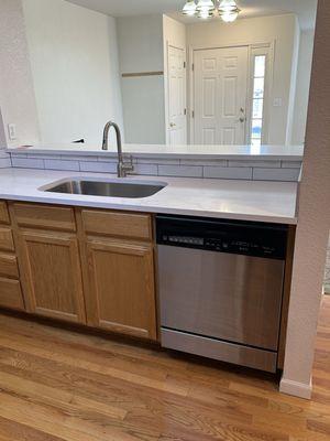 The side of the kitchen with an under mount sink and a pass through bar.