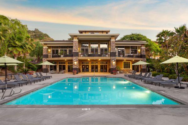 Swimming pool and spa surrounded by lounge chairs.