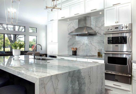 Quartz countertop and waterfall finish perfectly complemented by the full quartz backsplash.