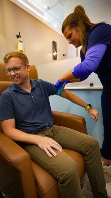A nurse setting up a client for a drip.