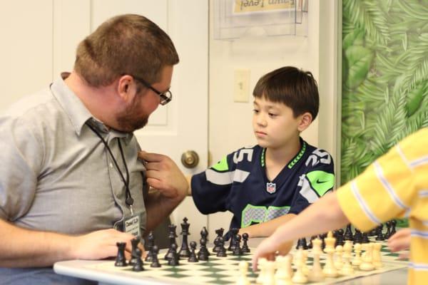 Coach Dale giving a Chess Immersion student a life lesson.