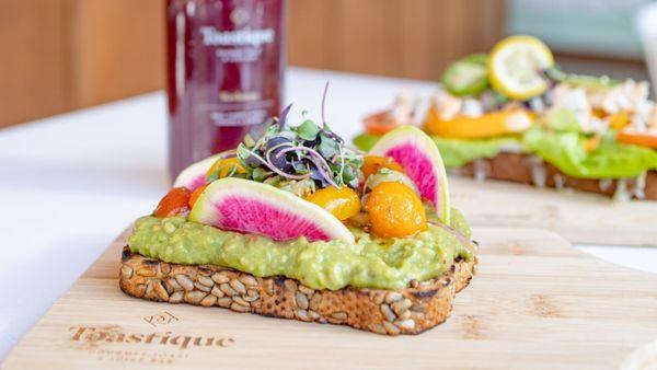 Avocado Smash with watermelon radish, marinated tomatoes, chili oil, microgreens on multigrain toast
