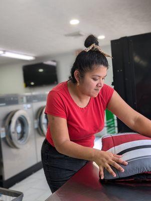 Friendly staff folding clean linen and laundry for our laundry guest or our pick up service in Columbus GA