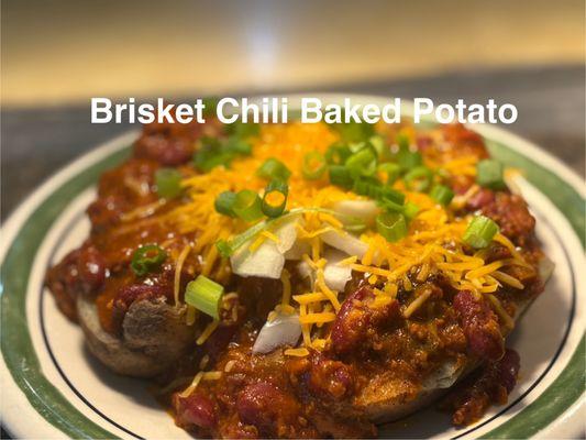 Baked Potato Topped With Our Signature Brisket Chili, Shredded Cheddar, Scallions and a side of Sour Cteam