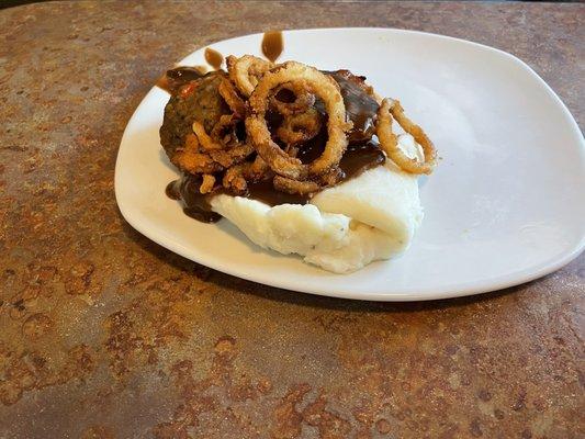 Meatloaf topped with grilled onion rings and real mashed potatoes with broccoli