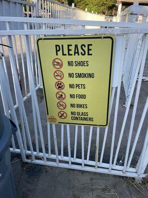 Sign that says no shoes yet very unsafe for kids with broken pieces everywhere