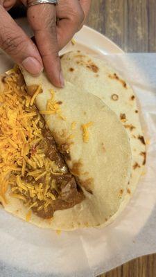 Carne guisada con queso on a flour tortilla