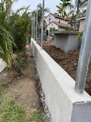 CMU Stucco wall with galvanized post masters for future wooden fence.