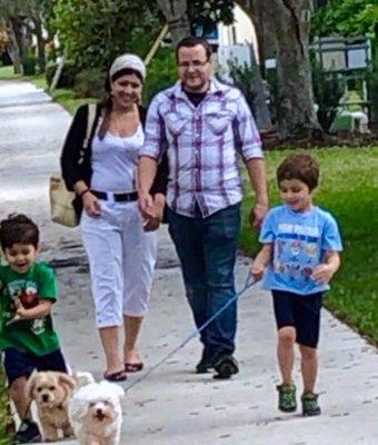 Mom and Dad watching their sons walk dogs.
