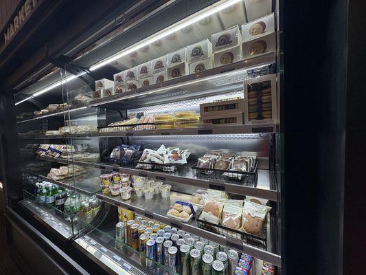 Roll cake, macaroons, cold sandwiches, yogurt, and beverages assortment