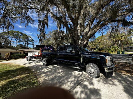 Pick up truck with hook lift system trailer and 16 yard dumpster collection