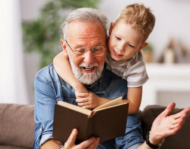 A grandfather reading to a little boy