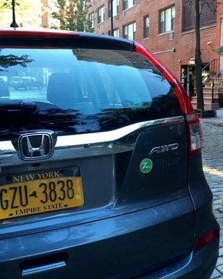 The parking lot is in the upper right hand corner- behind their zip car parked on the street.