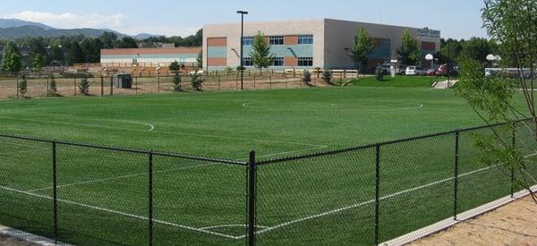Collegiate Academy with artificial turf athletic field in foreground.