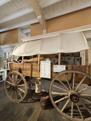 Replica of a trail wagon and supplies that many families used to make trek out West.