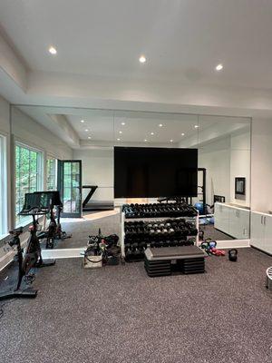 Floor to ceiling gym mirrors with the television incorporated.