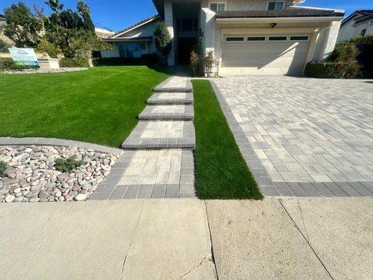 Artificial turf and paver driveway installation - modern front yard upgrade with steps, walkway, and low-maintenance landscape.