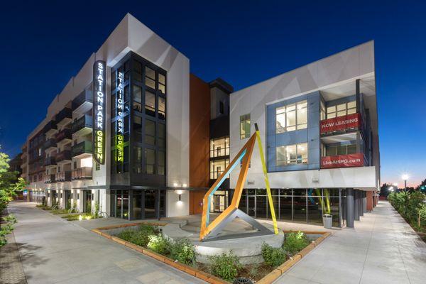Exterior of building at twilight with property name and landscaping.