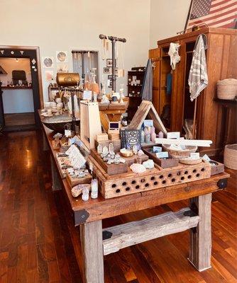 Main center table filled with various local /US made hand made jewelries, lotions, candles, perfumes, and self-care products.