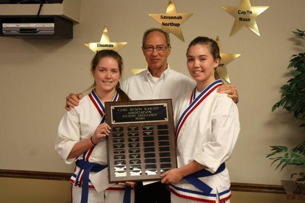 2 students pose with head instructor Mr. Willis to receive the Student Excellence Award.