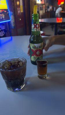 Sitting area / partial blue juke box My drinks are shot of Hennessy / side of Coca Cola His drink is a XX beer