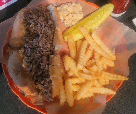 Philly cheesesteak with onions, fries and macaroni salad