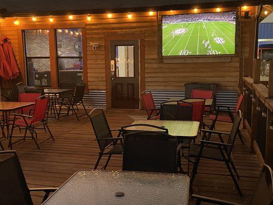 Outside patio seating with a tv.