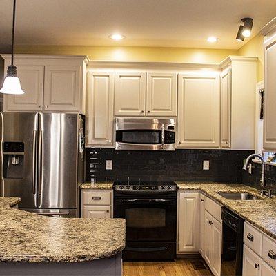 This kitchen went from warm maple to stark white with our custom color cabinet refinishing process.