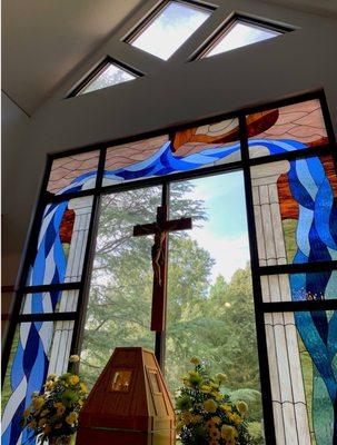 Our altar's beautiful stained window and forested campus beyond